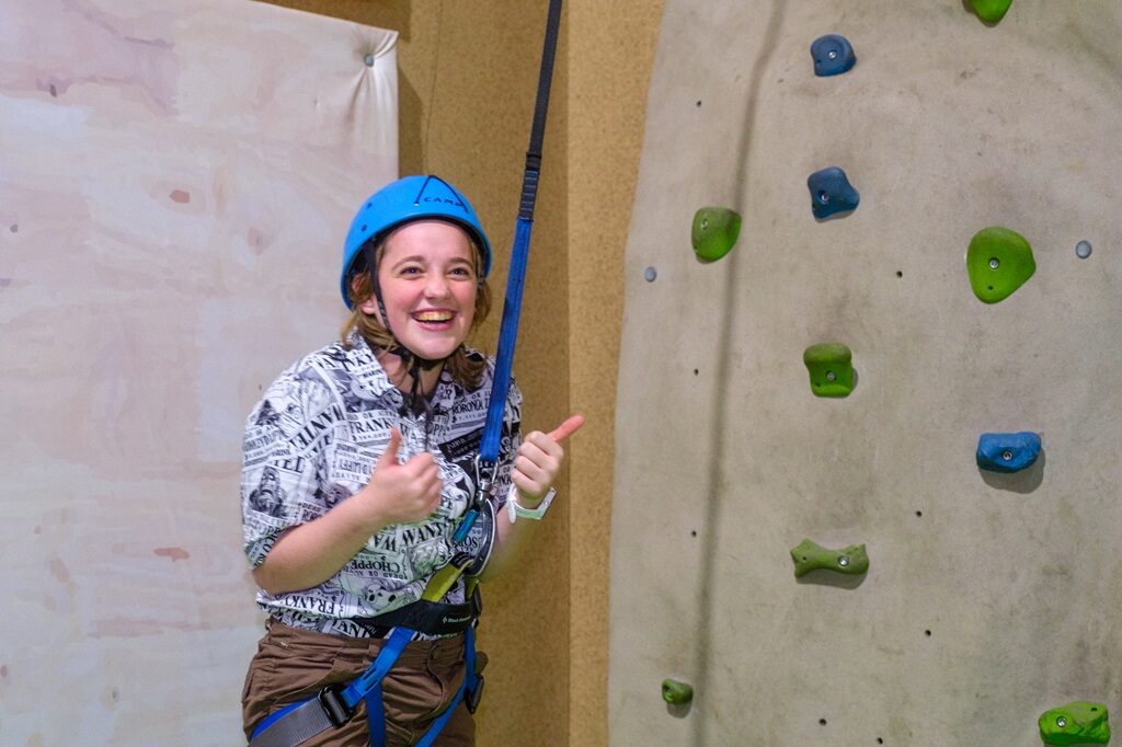 A camper on the rock climbing wall